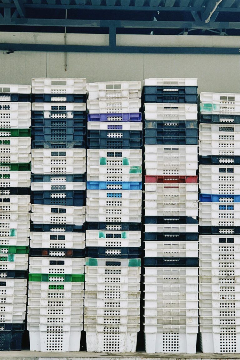 Organized stacks of colorful plastic crates in a warehouse in Konaev, Kazakhstan.